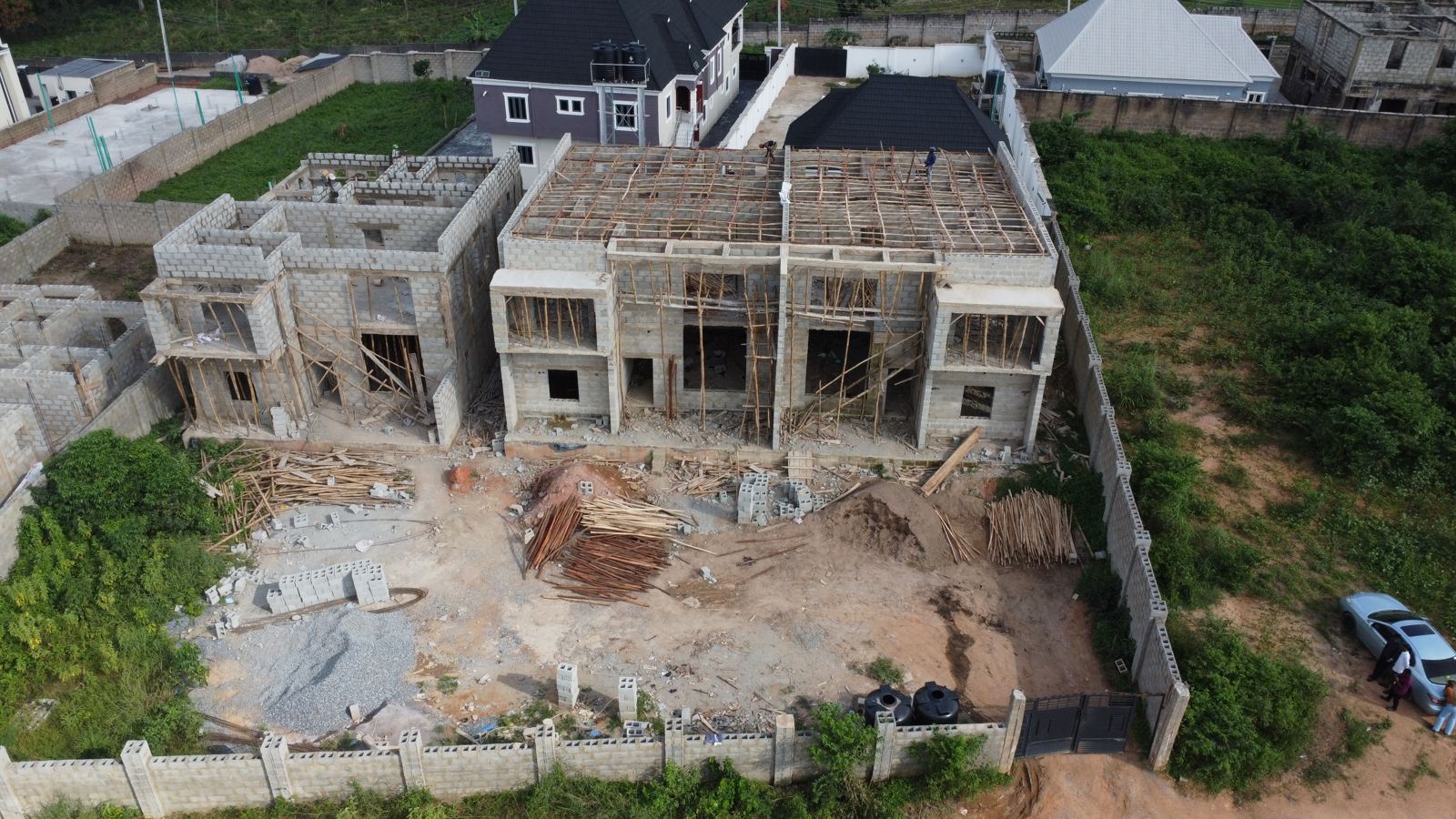 Aerial view of the Eden site at weeks 20 and 21: timber formwork and bamboo props covering the top of the two-storey block, with the ground-floor block beside it
